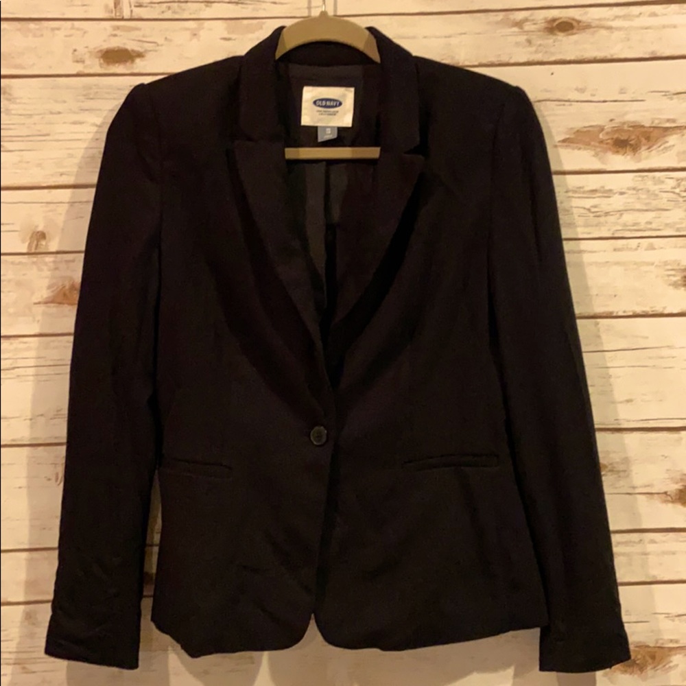 Black blazer. One button. Shoulder pads.